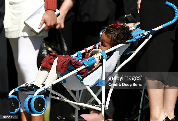 Jackie, Sean Taylor's daughter, 18 months, sleeps in her stroller as she arrives for her father's funeral services at Pharmed Arena on December 3,...