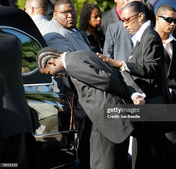 Mourner cries next to the hearse carrying the casket of Washington Redskins football player, Sean Taylor, during his funeral at the Pharmed Arena at...