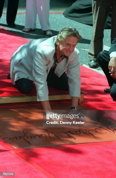 Actor Michael Douglas places his hand and foot prints at the Chinese Theater September 10, 1997 in Hollywood, CA. It has been reported that Douglas...