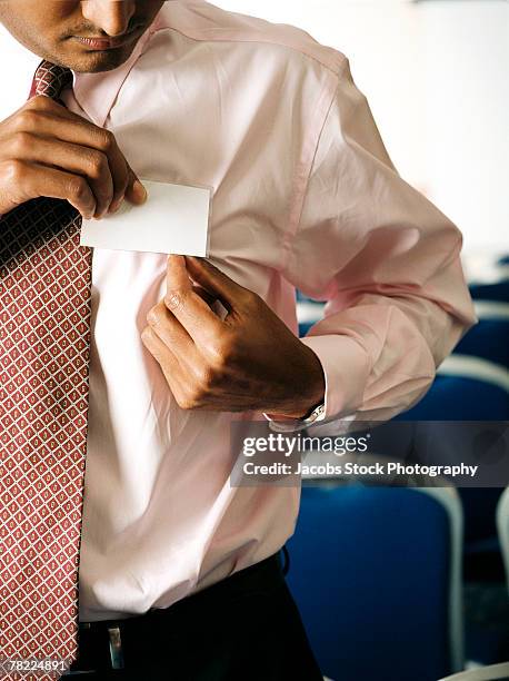 businessman affixing name tag - shirt tag stock pictures, royalty-free photos & images