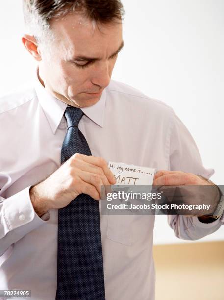 seminar attendee affixing name tag - name tag organizer stock pictures, royalty-free photos & images