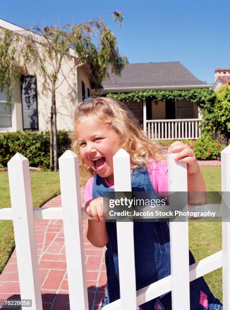 girl playing on white picket fence - white picket gate stock pictures, royalty-free photos & images
