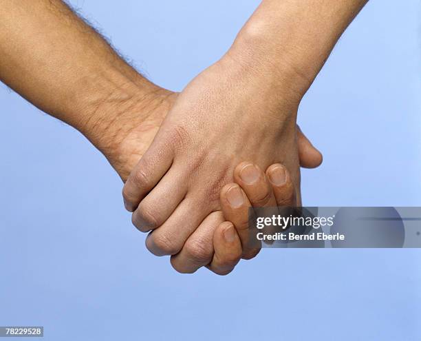 Two Hands Clasping Fingers Interlocked Closeup Side View High-Res