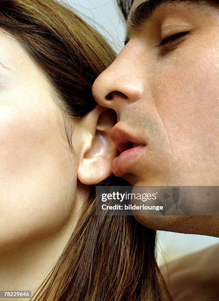 young man kissing woman?s ear - earlobe 個照片及圖片檔