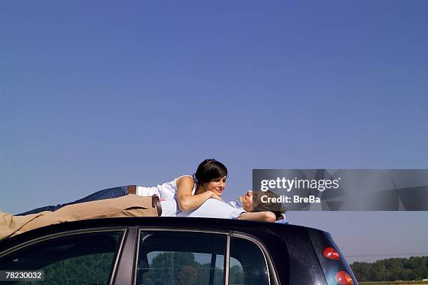 couple relaxing on car top - couple sleeping in car photos et images de collection