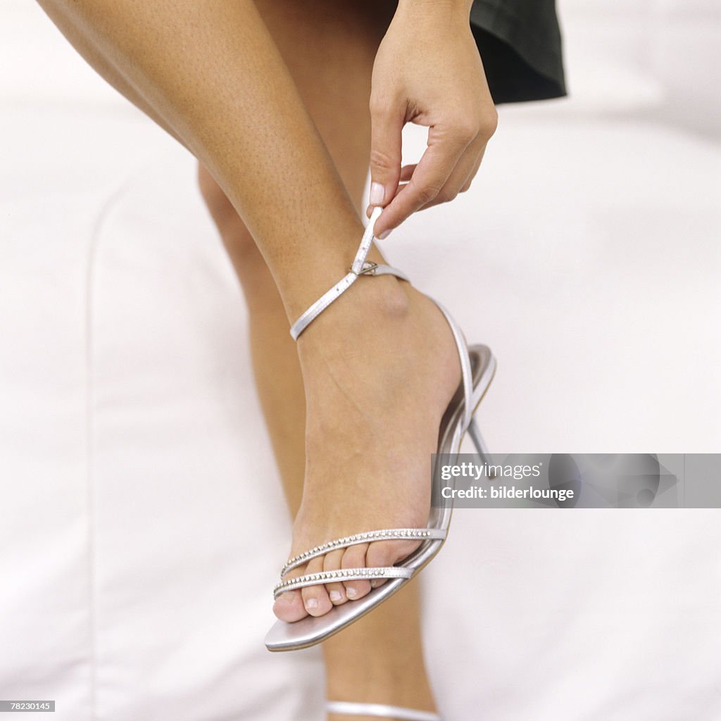 Close-up of woman adjusting her shoe strap