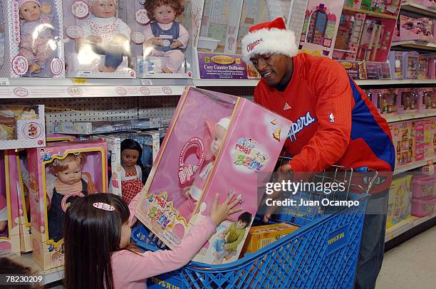 Al Thornton of the Los Angeles Clippers helps a young girl shop during the Clippers Foundation holiday toy drive at Toys "R" Us December 3, 2007 in...