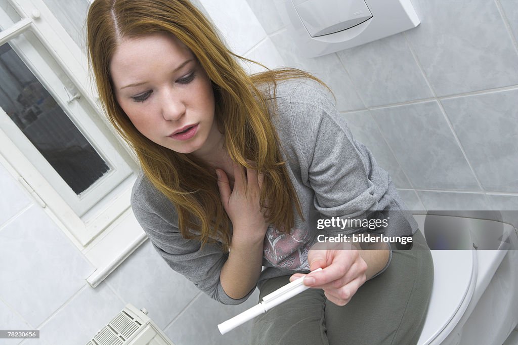 Teenage girl looking at pregnancy test