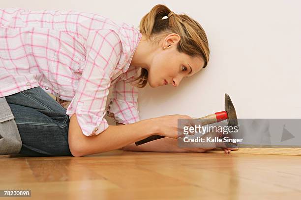 close-up of young woman doing home improvement with hammer and nail - parquet cloué photos et images de collection