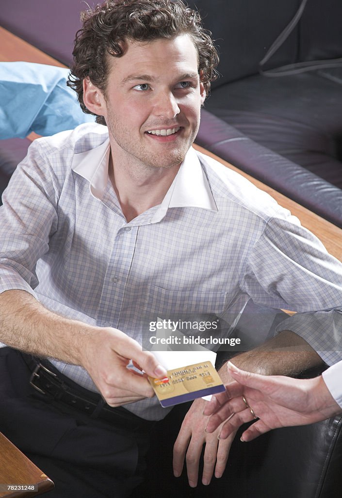 Young man paying with credit card in restaurant