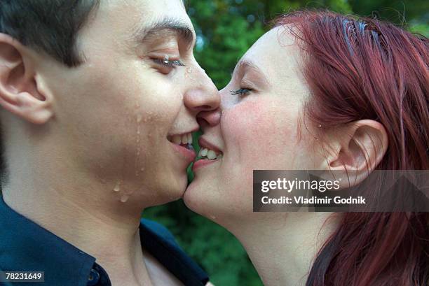 young couple about to kiss in the rain - rain kiss stockfoto's en -beelden