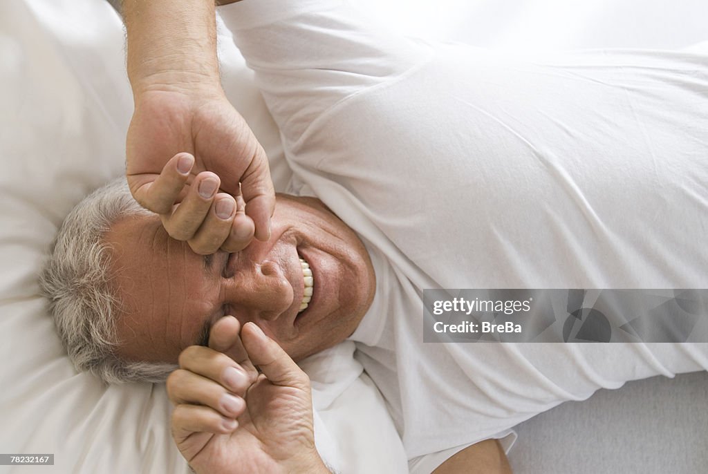 Portrait of mature man awaking rubbing his eyes