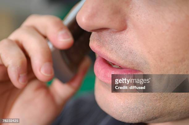 close-up of mouth of young man with cellphone - extreme close up mouth stock pictures, royalty-free photos & images