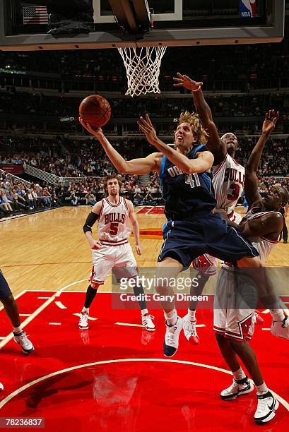 Dirk Nowitzki of the Dallas Mavericks goes to the basket past Luol Deng and Ben Wallace of the Chicago Bulls on December 3, 2007 at the United Center...