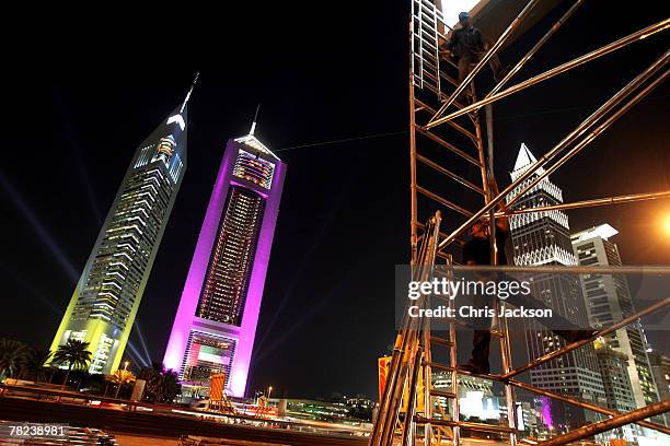 Indian expatriot workers construct an advertising hoarding late at night in front of the iconic Emirates Towers on December 3, 2007 in Dubai, United...