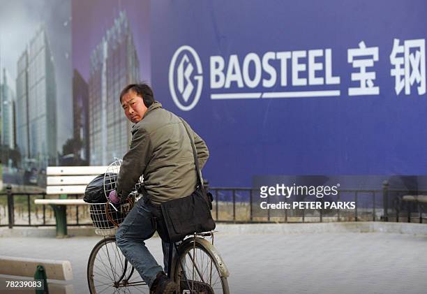 Man cycles past a bilboard advertising China's largest steel producer Baosteel Group in Beijing, 04 December 2007. Baosteel Group is likely to launch...