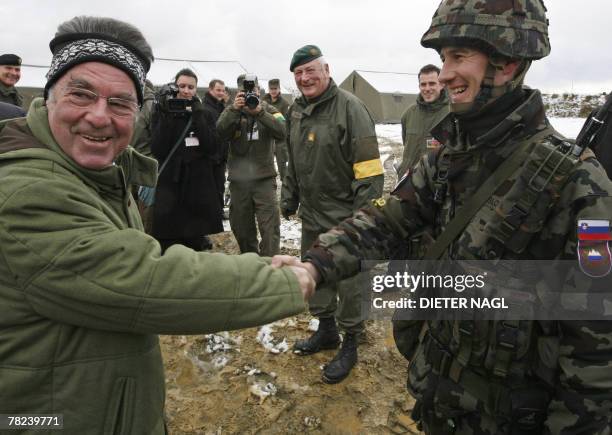 Austrian President Heinz Fischer shakes hands with Slovenian Staff Sergeant Daijan Slekovec from Maribor 04 December 2007 during international...