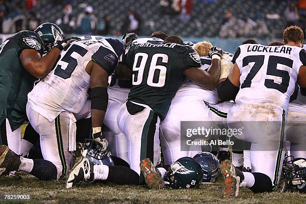 Players of the Seattle Seahawks and the Philadelphia Eagles kneel on the field in a moment of silence for slain football player Sean Taylor of the...