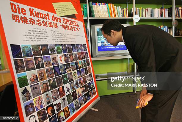 Chinese man views a poster promoting the recently cancelled cover art exhibition for the German news magazine Der Spiegal, in Shanghai, 05 December...