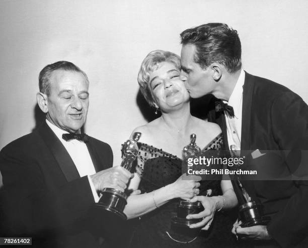 American director William Wyler , French actress Simone Signoret and American actor Charlton Heston with their trophies at the Academy Awards...
