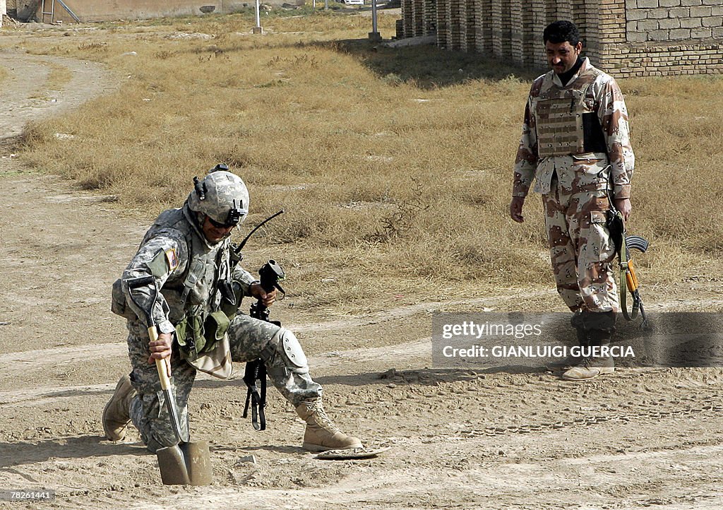 An Iraqi Army soldier looks on as a US s