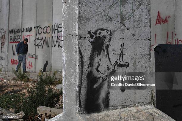 New stencil painting on a concrete barricade by elusive British graffiti artist Banksy shows a rat holding a slingshot December 5, 2007 opposite an...