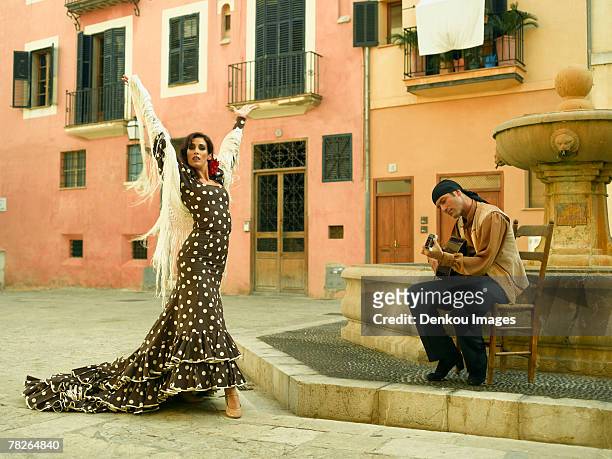 young woman dancing and a mid adult man playing the guitar - baile flamenco fotografías e imágenes de stock