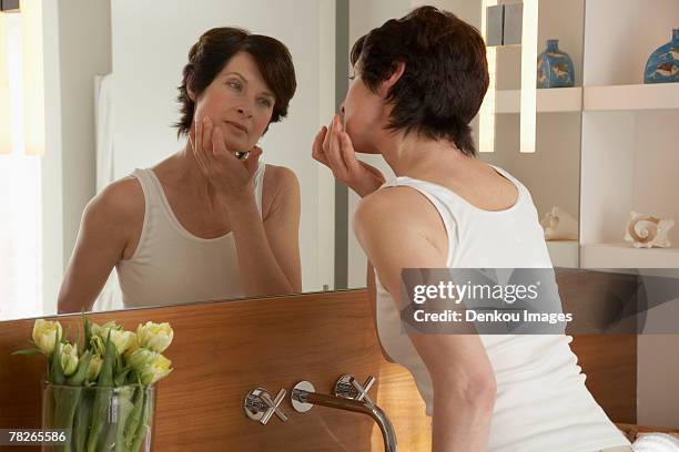 rear view of woman standing in front of a mirror - woman rear view mirror stock pictures, royalty-free photos & images