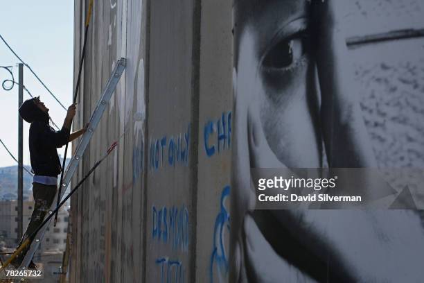 The Italian street artist Blu paints graffiti on Israel's separation barrier December 5, 2007 where is cuts a path into the biblical West Bank city...
