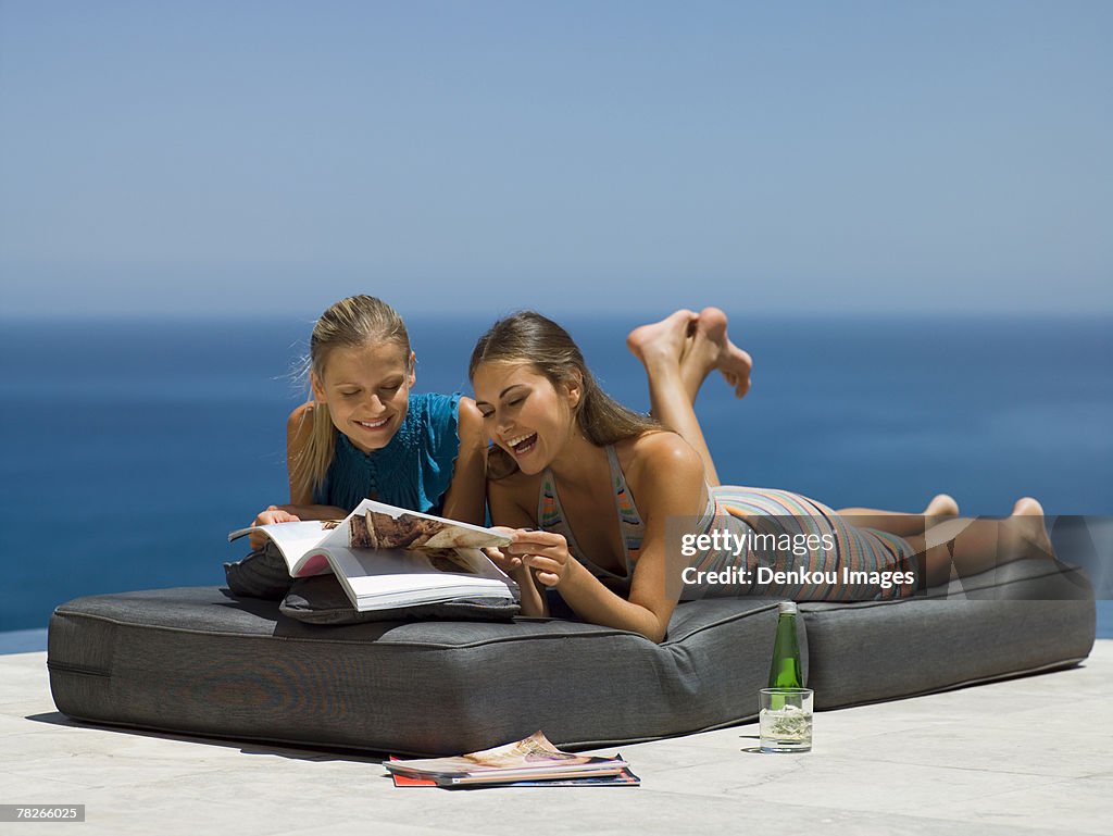 Women lying down and reading magazines.