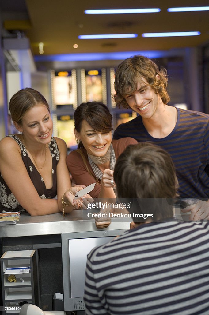 People buying movie tickets at the box office.