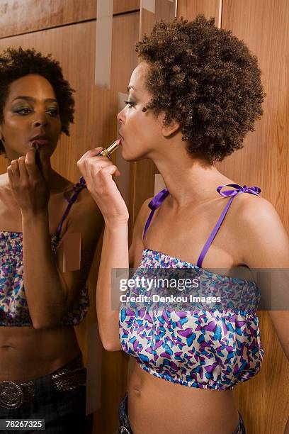 woman applying lipstick. - nightclub bathroom stockfoto's en -beelden