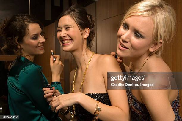 women applying make up. - nightclub bathroom stock pictures, royalty-free photos & images