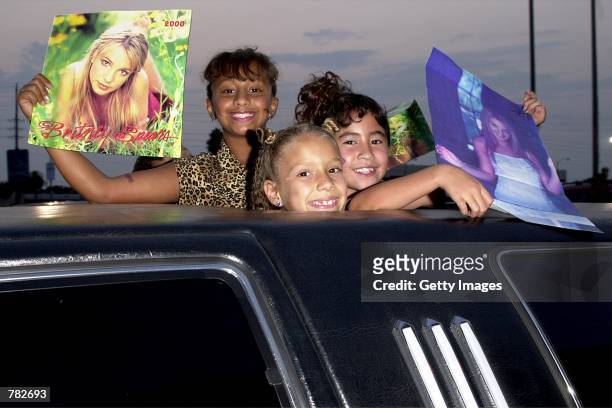Young Britney Spears fans hold up her posters as they arrive by limousine at her Century City concert July 31, 2000 in Los Angeles, CA.