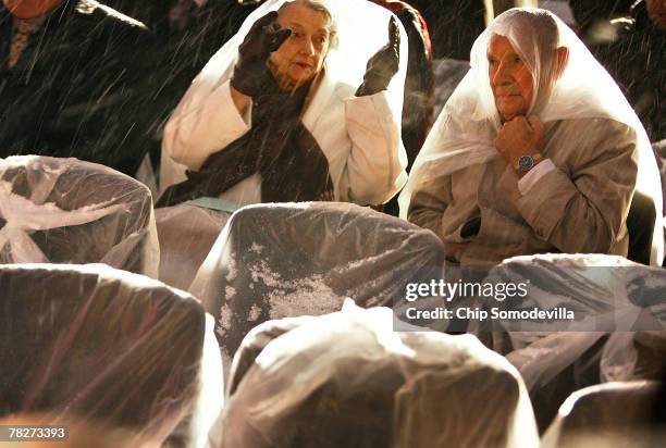 Rhoda Charron and husband Art Charron use plastic bags to take shelter from snow and freezing temperatures during the annual lighting of the U.S....