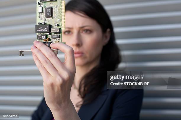 businesswoman holding a circuit board - printed circuit b stock pictures, royalty-free photos & images
