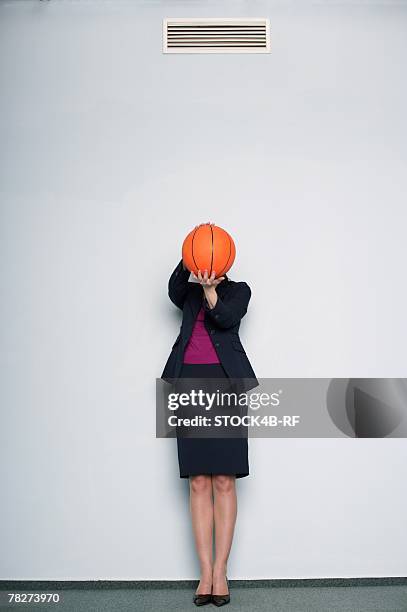 businesswoman covering face with a basketball - rf business stock pictures, royalty-free photos & images