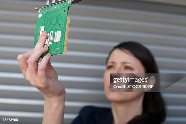 businesswoman holding a sound card - printed circuit b stock pictures, royalty-free photos & images