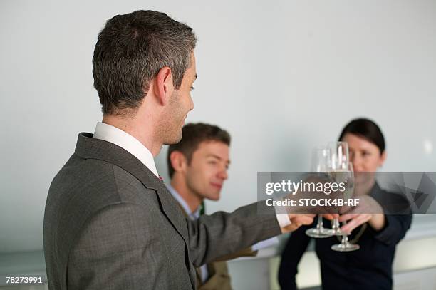 three businesspeople clinking glasses - dark haired man gray shirt with wine stock pictures, royalty-free photos & images