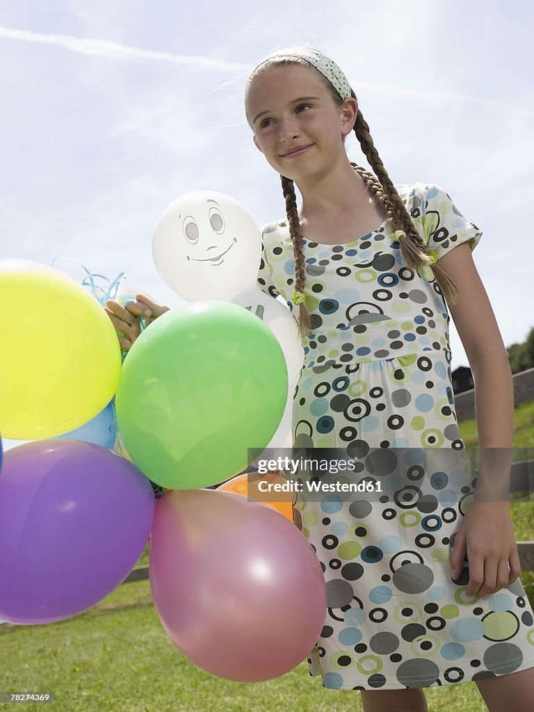 Girl holding balloons, portrait
