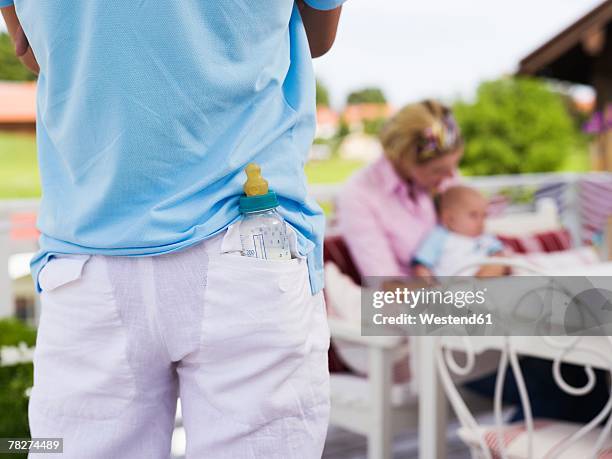 man with baby bottle in pocket, rear view - back pocket photos et images de collection