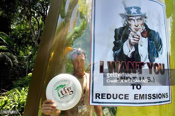 An environmental activist is seen inside an inflated plastic tree next to a placard during the demonstration at the venue of the UN Climate Change...