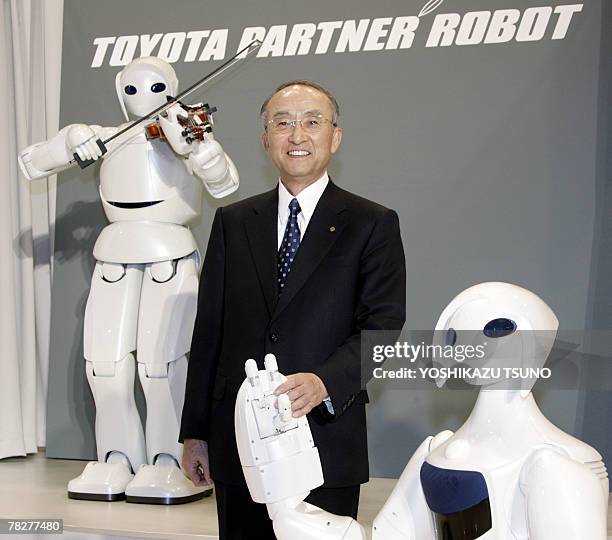 Japan's auto giant Toyota Motor president Katsuaki Watanabe introduces the company's new partner robot Robina and a violin playing robot at the...