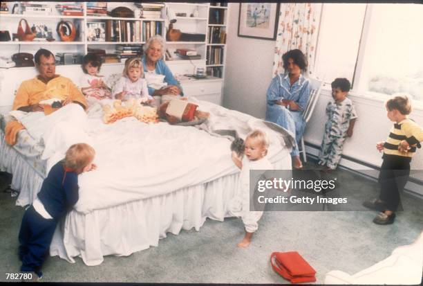 George Bush and his wife Barbara sit in their bed as six of their fourteen grandchildren play around them in Washington, D.C. Bush was born June 12,...