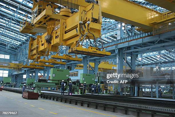 Filipino workers man huge lifting machines inside the production plant area of South Korea's Hanjin Heavy Industries and Construction Corp....