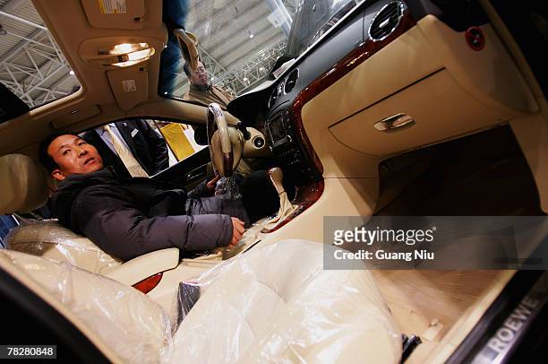Man tests a China-made Roewe 750 as he visits Auto Exhibit Trade Show of Beijing 2007 on December 6, 2007 in Beijing, China. During the first 10...