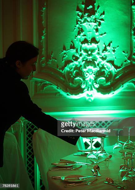 Member of staff checks glasses on a table in the ballroom at the Savoy Hotel on December 6, 2007 in London. Some of the fixtures and fittings are to...