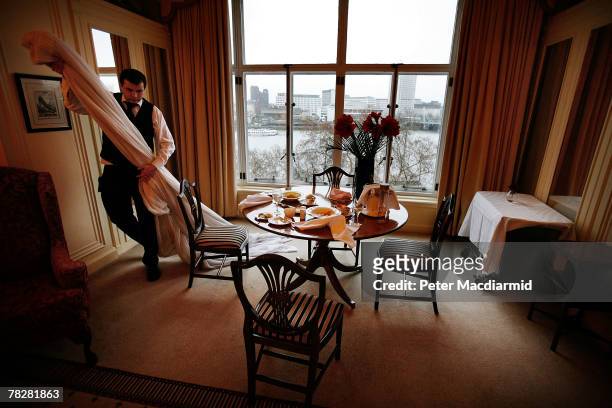 Member of staff removes net curtains for cleaning from the Monet Suite at the Savoy Hotel on December 6, 2007 in London. Some of the fixtures and...