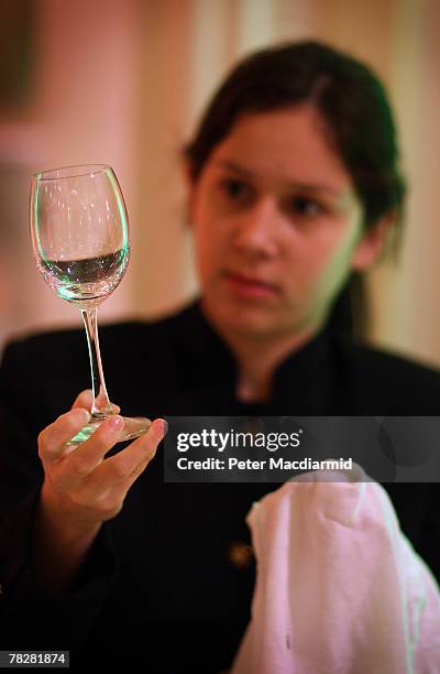 Member of staff checks wine glasses in the ballroom at the Savoy Hotel on December 6, 2007 in London. Some of the fixtures and fittings are to be...