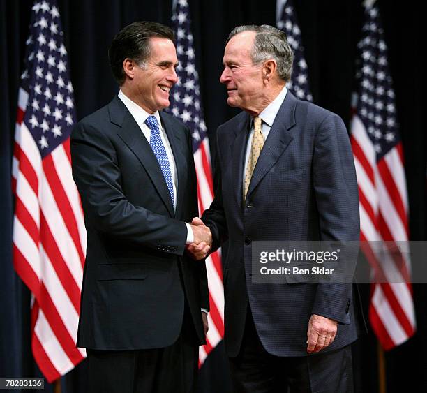 Former Massachusetts Governor and Republican President hopeful Mitt Romney shakes hands with former U.S. President George Bush before speaking on...